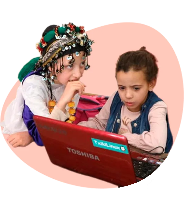 Dos niñas trabajando con un ordenador portátil con TxikiLinux